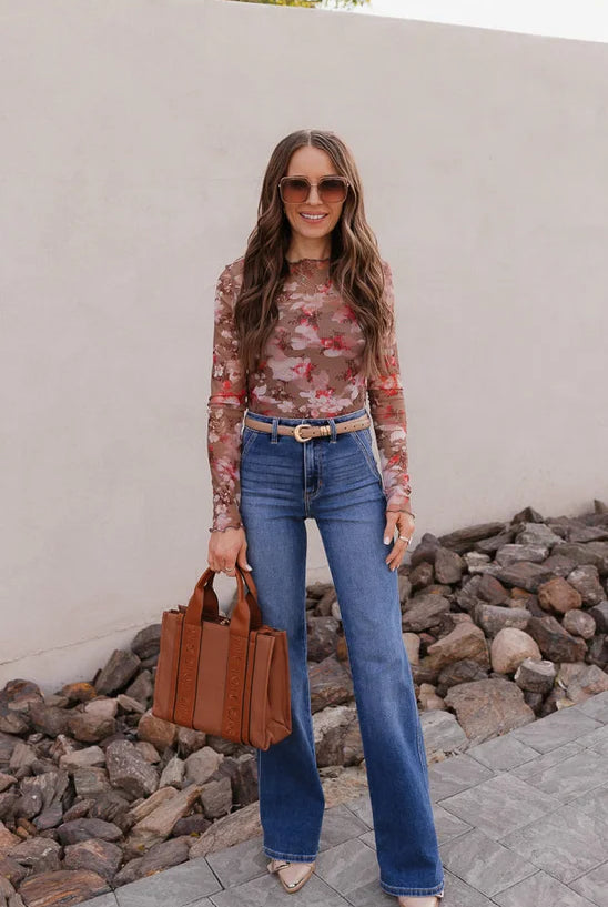 Woman in jeans with brown bag and floral top