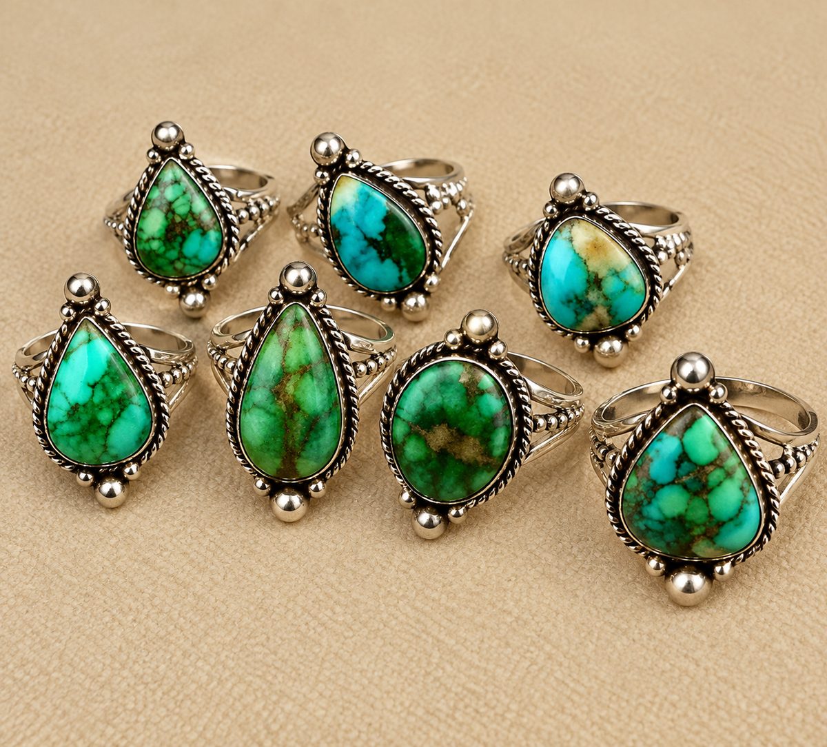 Ornate Turquoise Rings on Beige Fabric.png