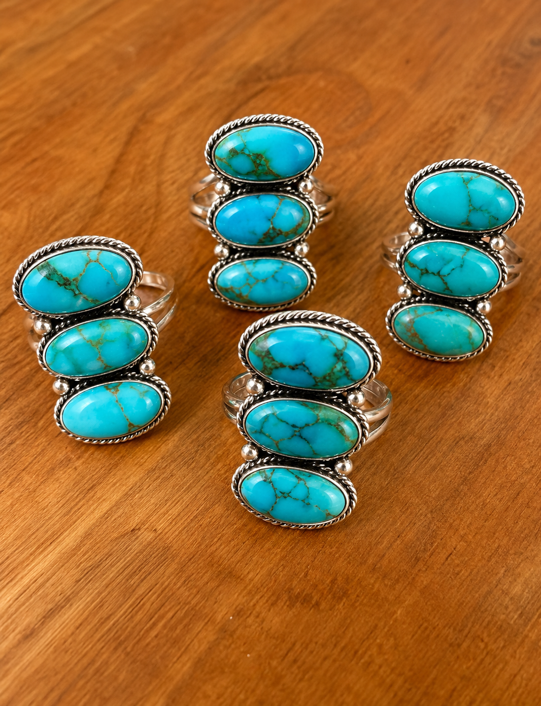 Turquoise Triple-Stone Rings on Wood.png