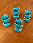 Turquoise Triple-Stone Rings on Wood.png